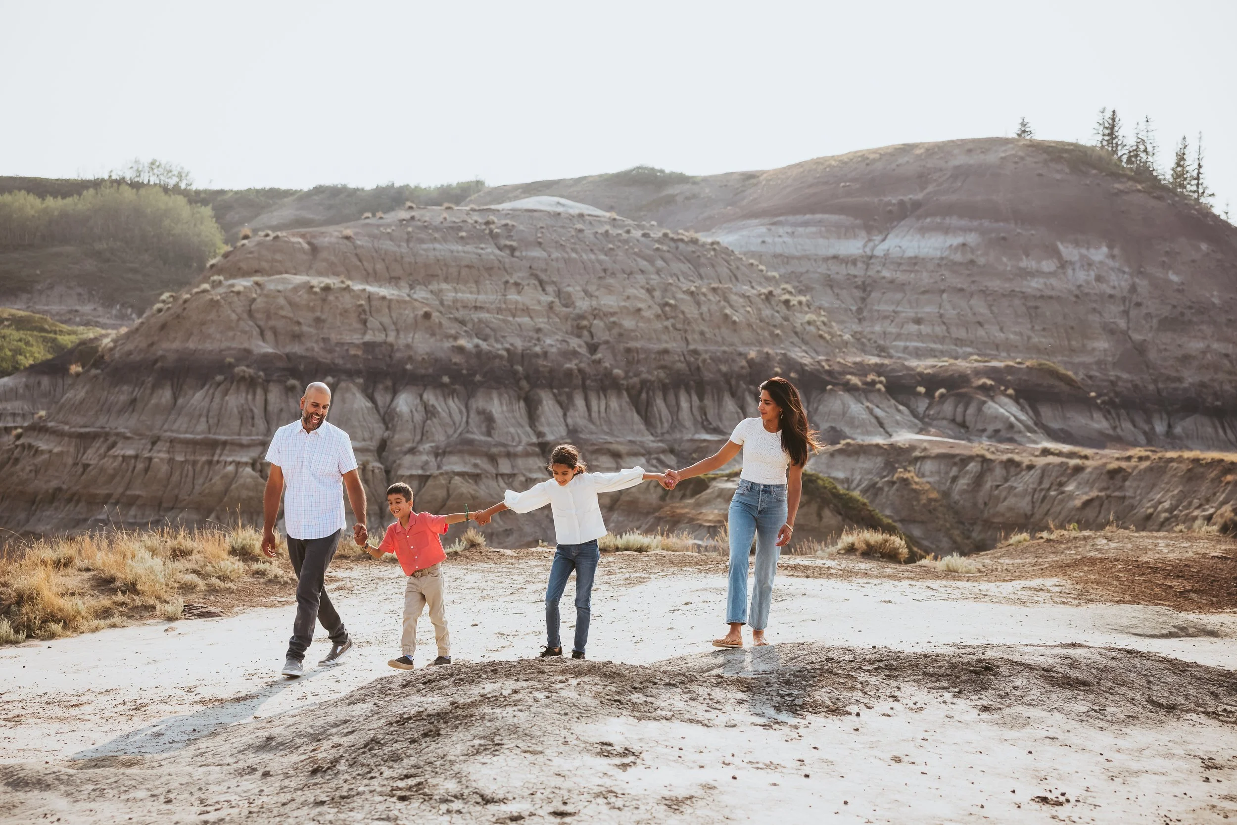 Family walking together during an adventure photoshoot in the Alberta Badlands near Drumheller