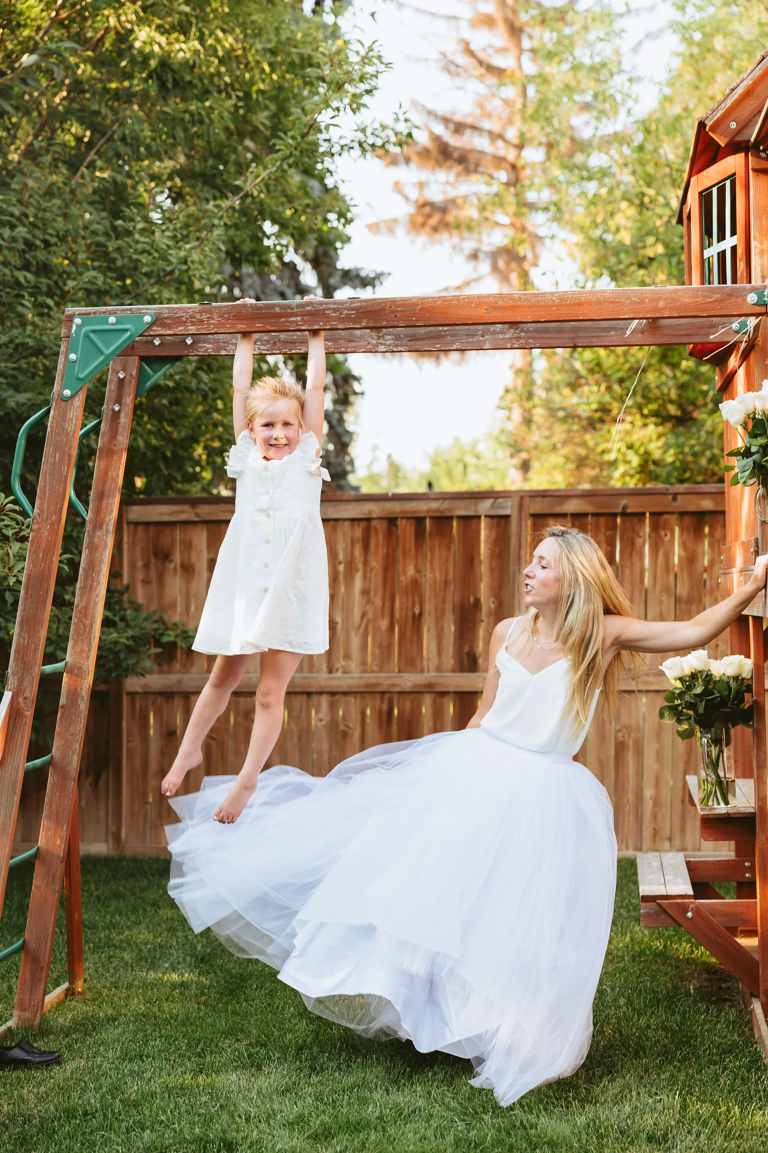 Bride sharing a playful moment with her daughter during a relaxed backyard wedding celebration in Calgary, Alberta.