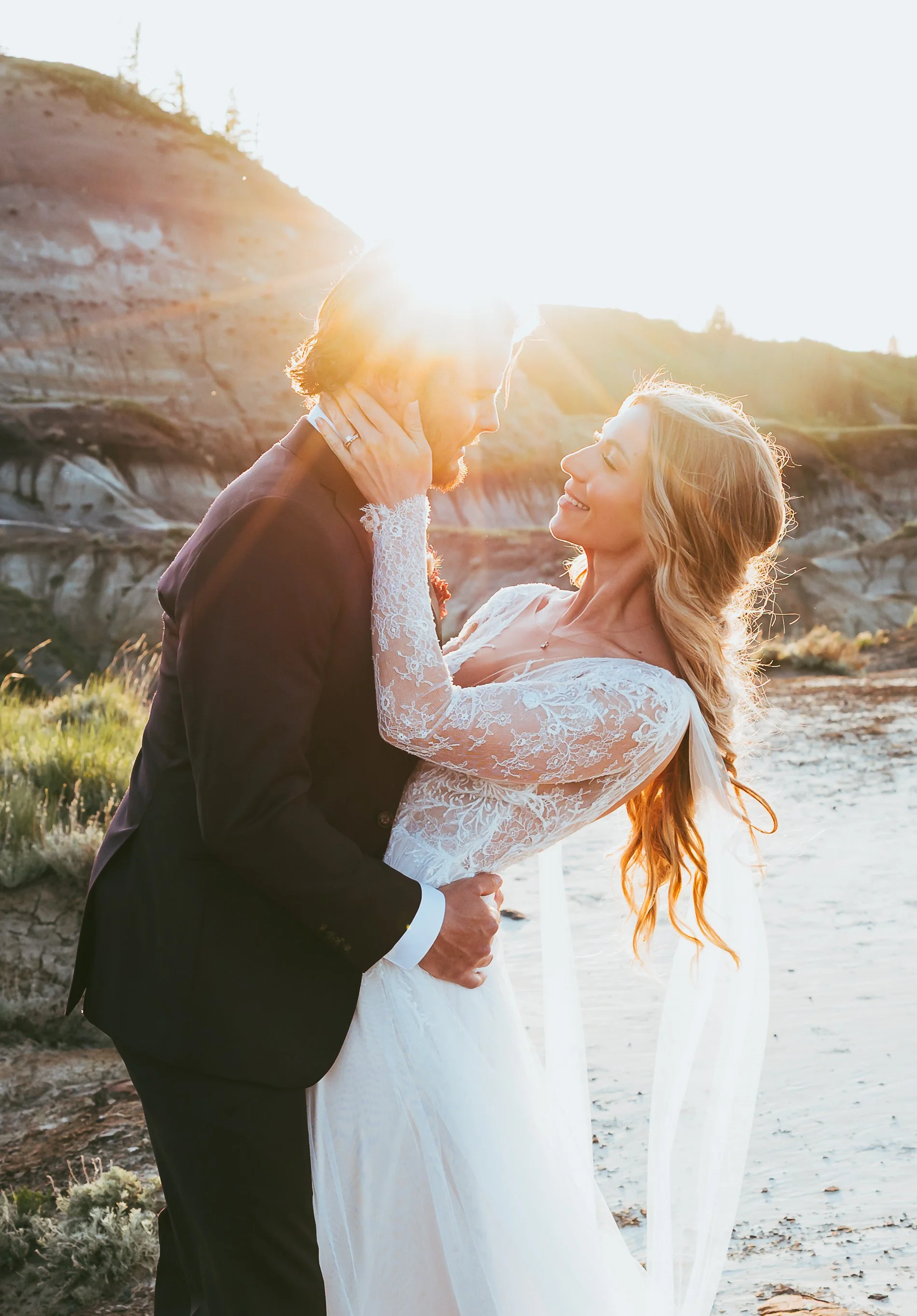 Bride and groom embracing at sunset among the Alberta Badlands during an intimate Drumheller wedding.
