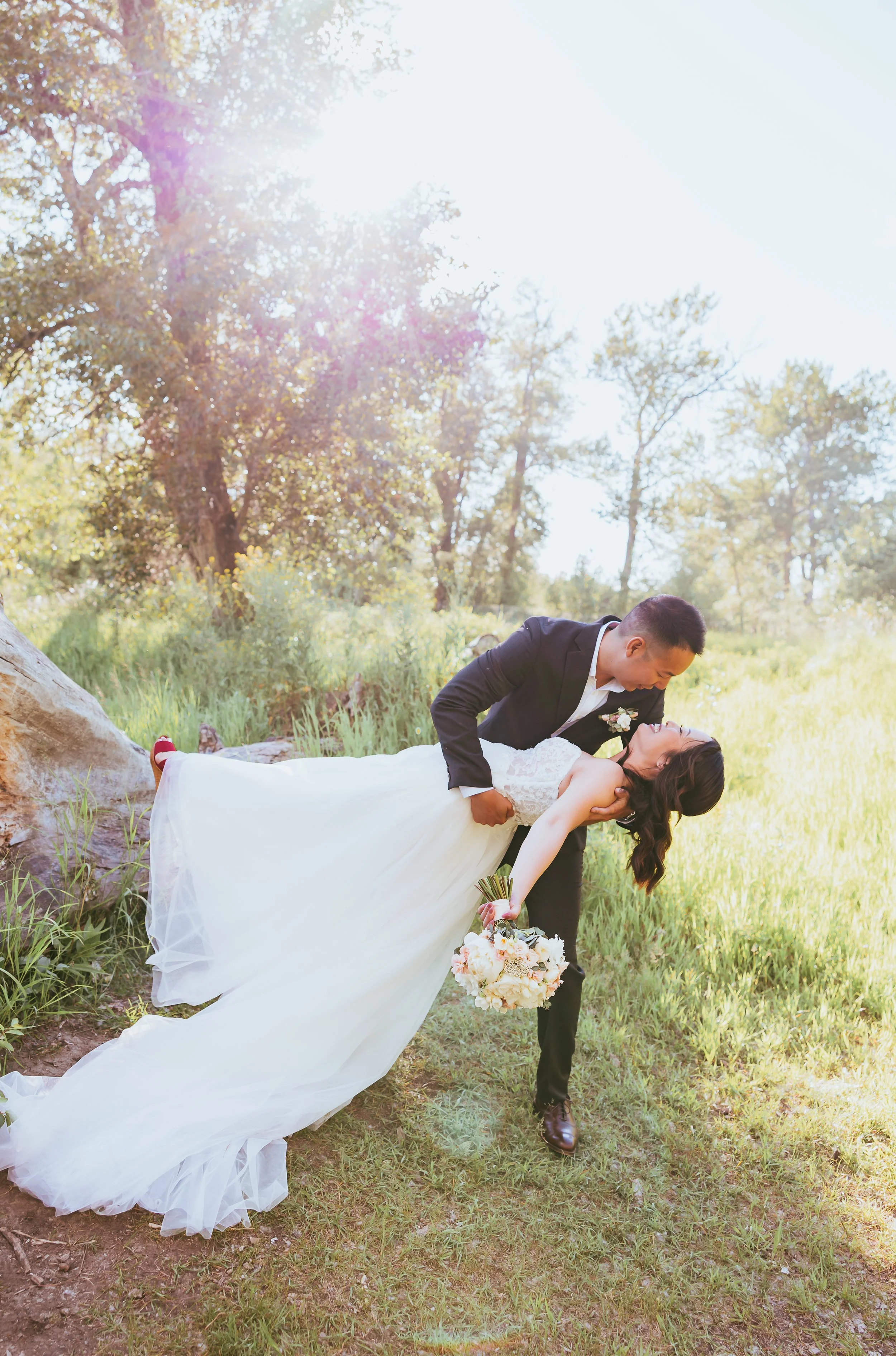 Groom dipping his bride during romantic golden-hour wedding portraits at an intimate outdoor wedding in Calgary, Alberta.