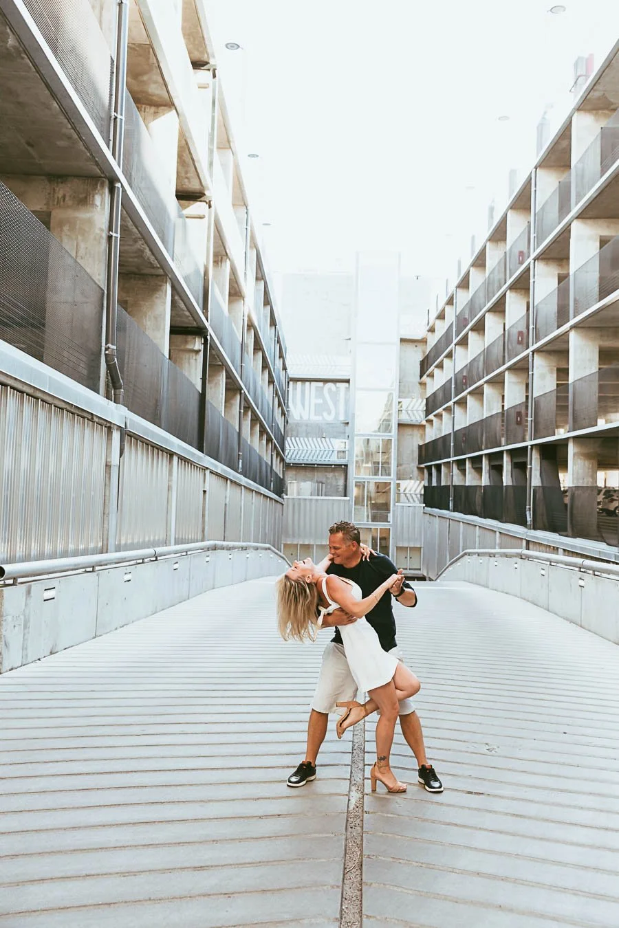 Urban engagement session in Calgary Alberta with city skyline, modern architecture, and couple walking through downtown streets