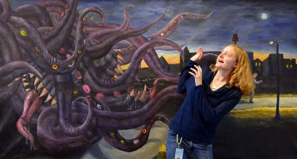 The artist displays the large scale of the piece.  