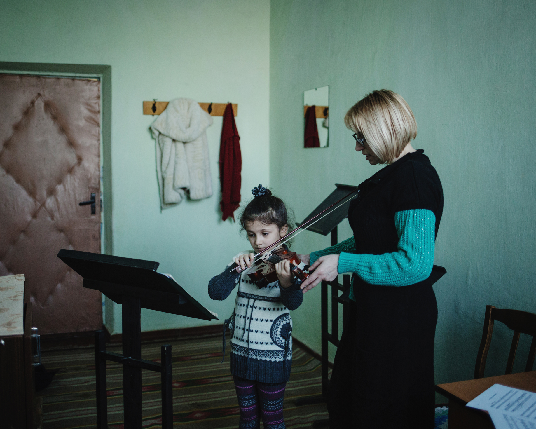  Evgenia Duloglu teaches violin to the young Arina in the House of Culture. 