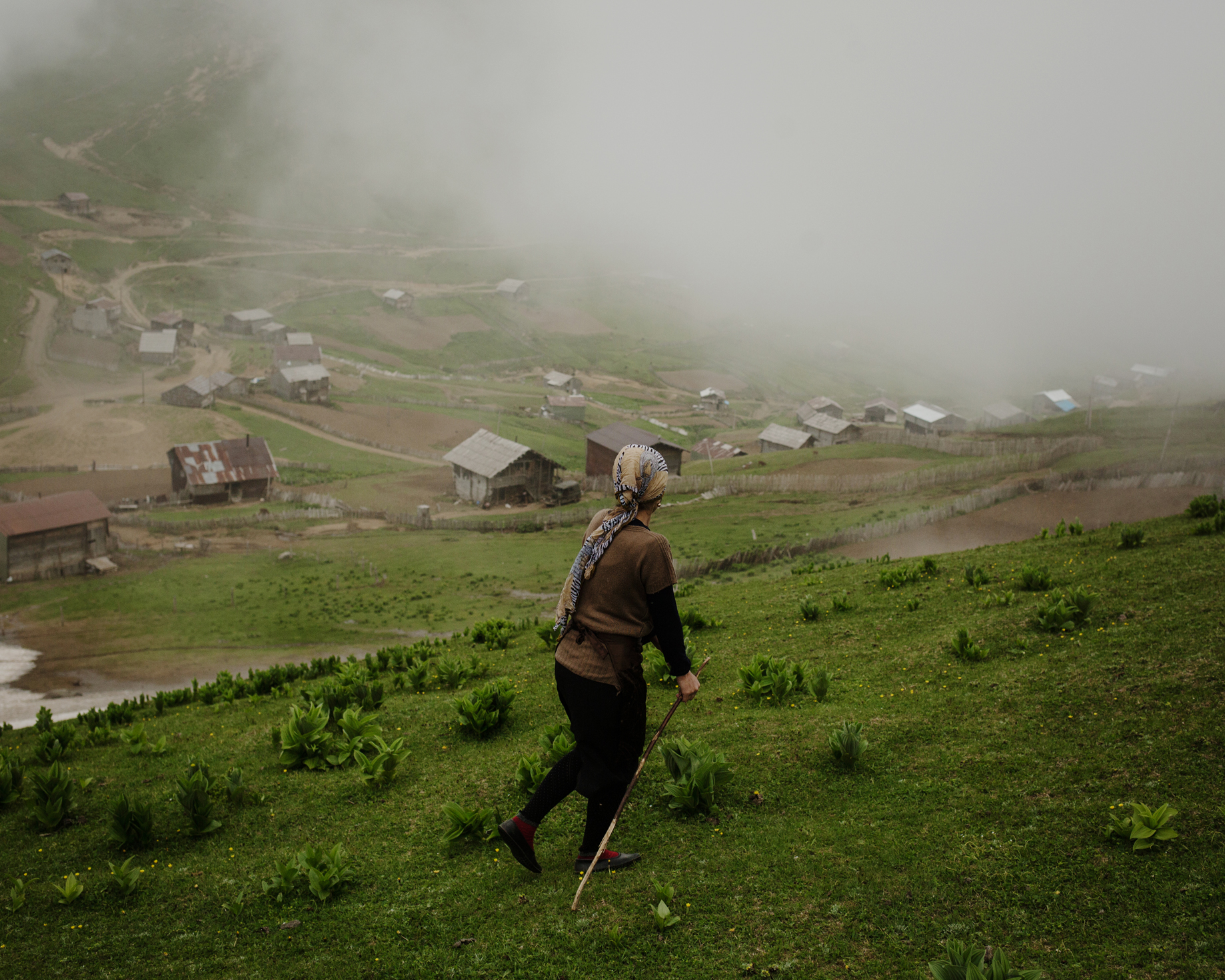  Zortikheli. A woman goes and pick her animals while clouds arrive on the village and rain threatens. 