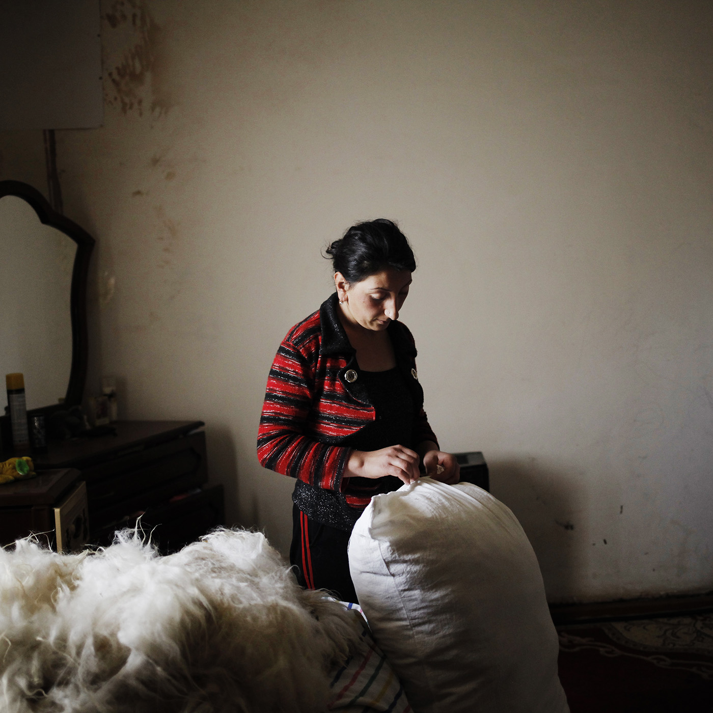  Early in the morning, Ruzanna prepares bed mattress for her children with sheep wool bought a few days ago.    