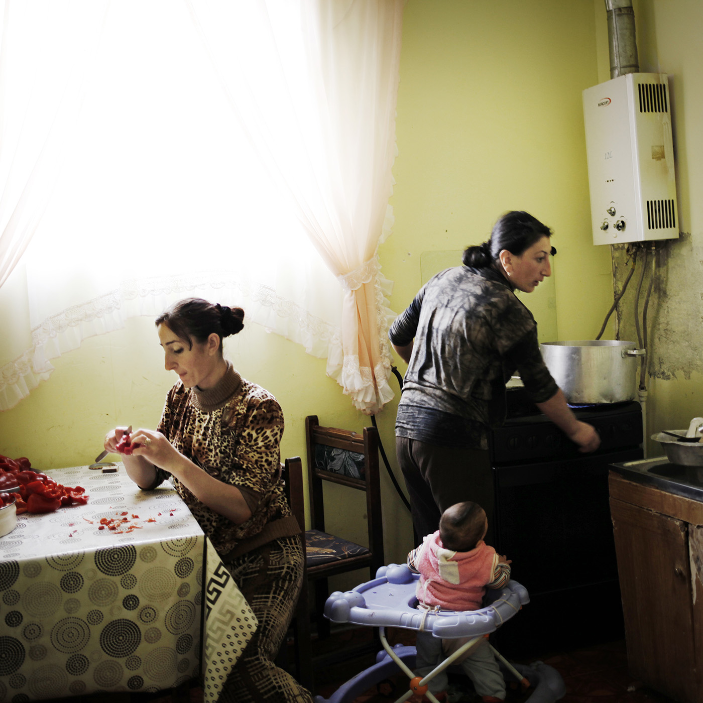  It’s time to prepare cans for winter. Several days of work will be needed to prepare the stock for the winter. Anoush is slicing peppers while Ruzanna cooks them. In the same time they are watching Naïre, Ruzanna's daugher. 