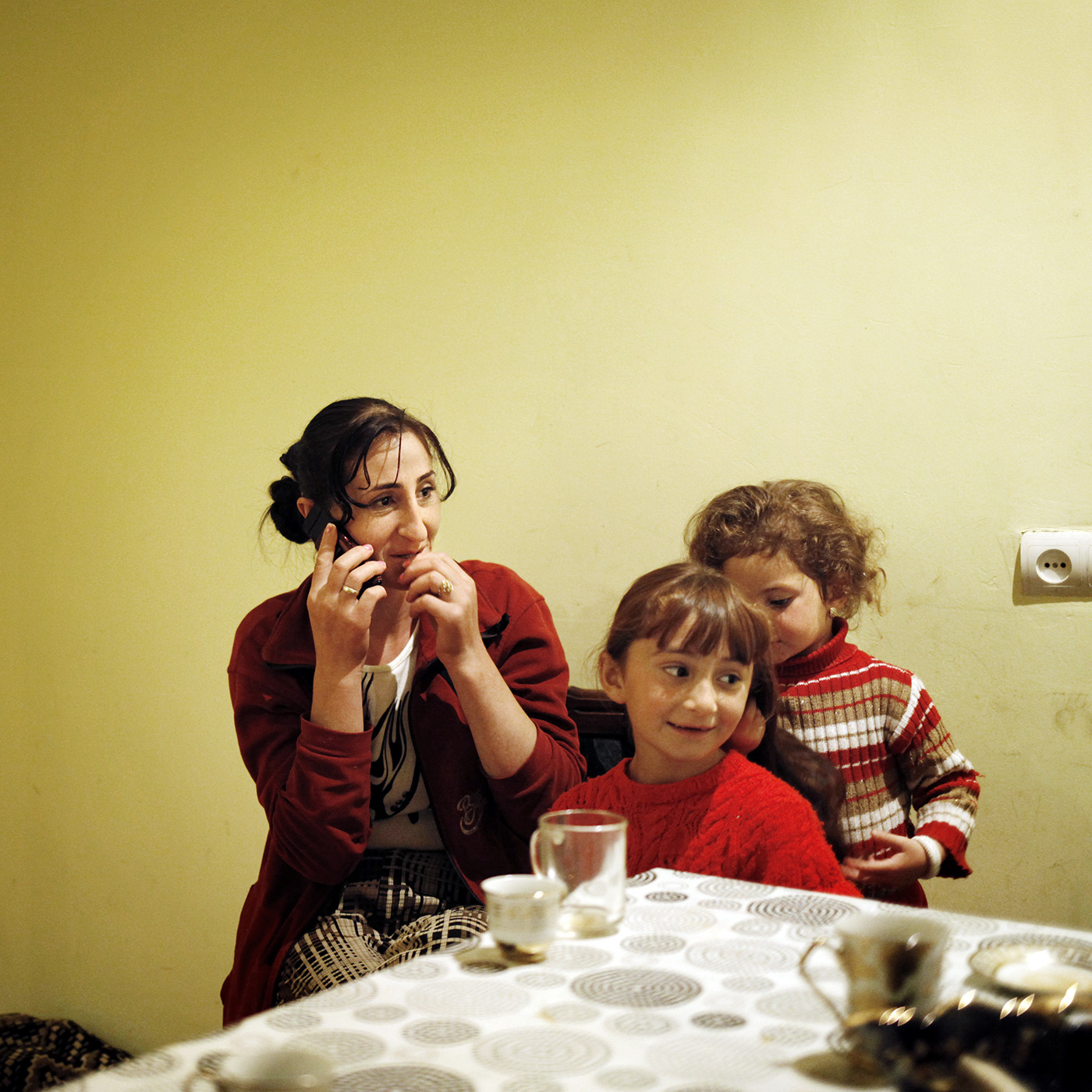  Anoush is calling her husband in Russia. On her the right are her two daughters, Lilith is doing Asmik's hair. 