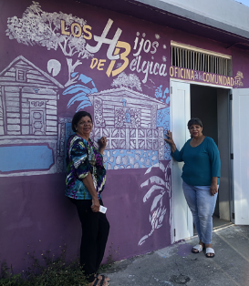 Josefina Pacheco (left) and her sister in front of the Belgica community center being refurbished.