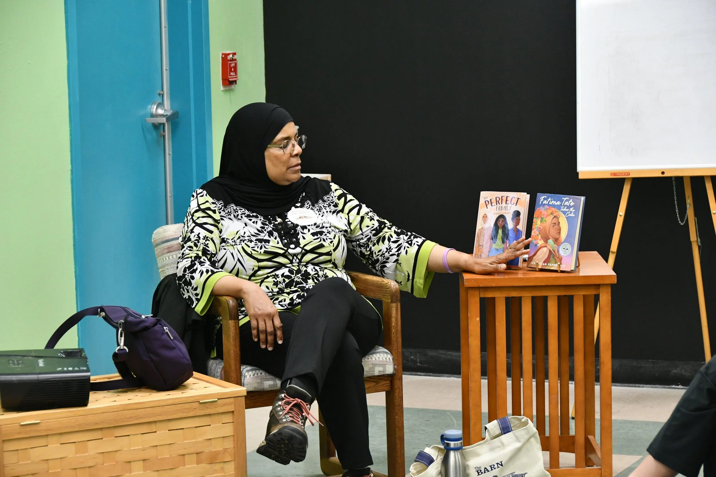Khadijah VanBrakle presenting two of her books, "My Perfect Family and Fatima Tate Takes the Cake."
