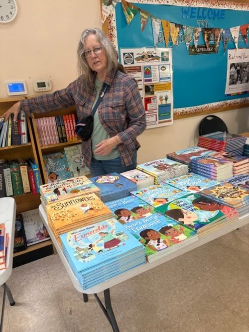 Nancy Guinn, of local bookseller Bookworks, next to participating authors' books for sale at the Book Fair.