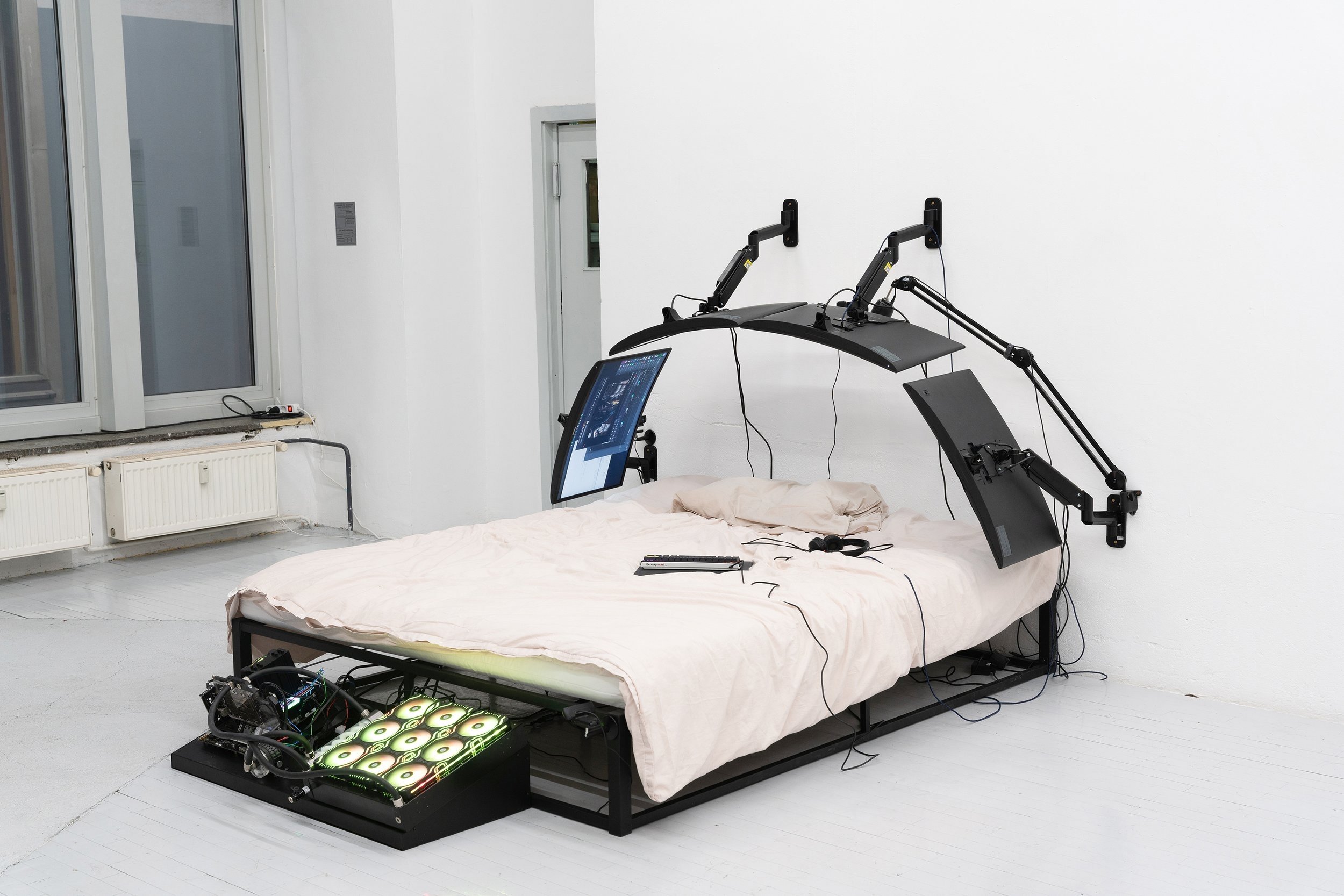  Filip Kostic,  Bed PC 2 , Custom built water cooled computer built into the frame of the bed. Variable screens to create a shield like shape, blanket, and pillows. Variable peripherals including keyboard, mouse, streaming microphone, and cameras for