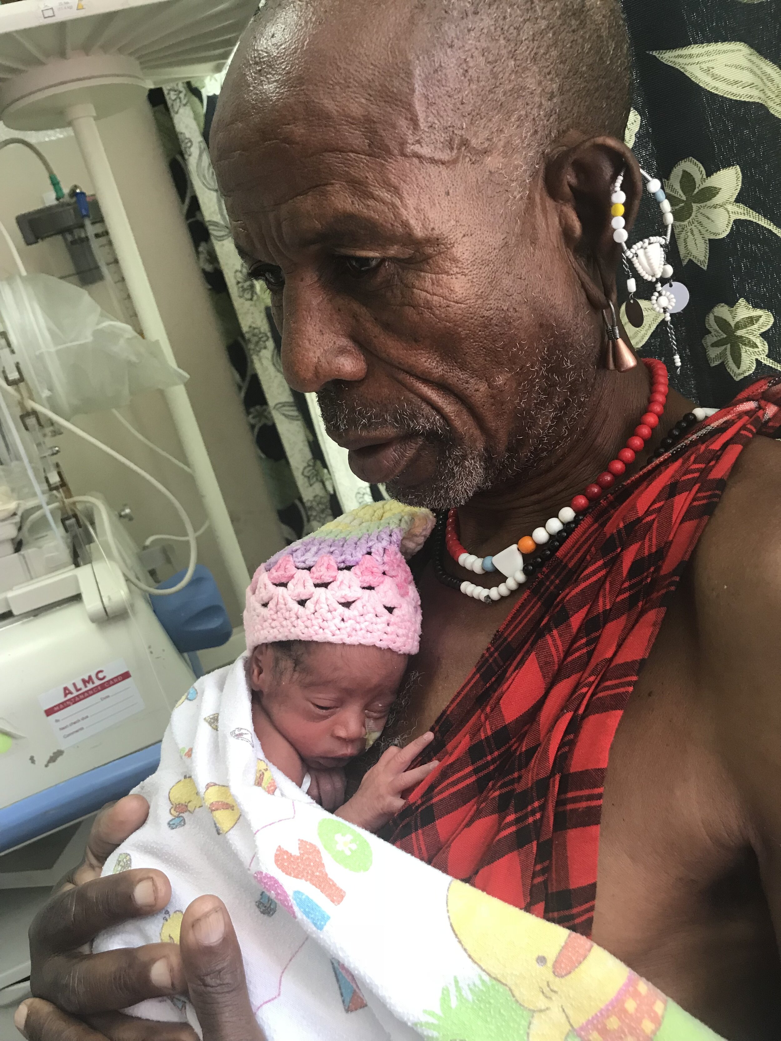 Maasai Father holding 31-week triplet daughter.jpg