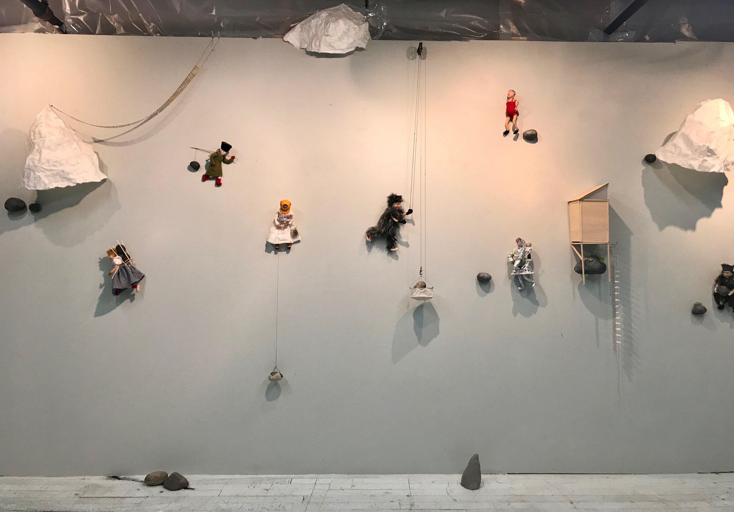 INSTALLATION VIEW / 3D PAINTING This wall installation is comprised of felted fiber figures scurrying with their loads of rocks and bits of icebergs. In a continuation of the Terra (not so) Firma theme, we see the impact of climate change, with icebergs in massive chunks floating by on the horizon. Women carry rocks hither thither, while wearing remarkable outfits because of course, they do, and can.