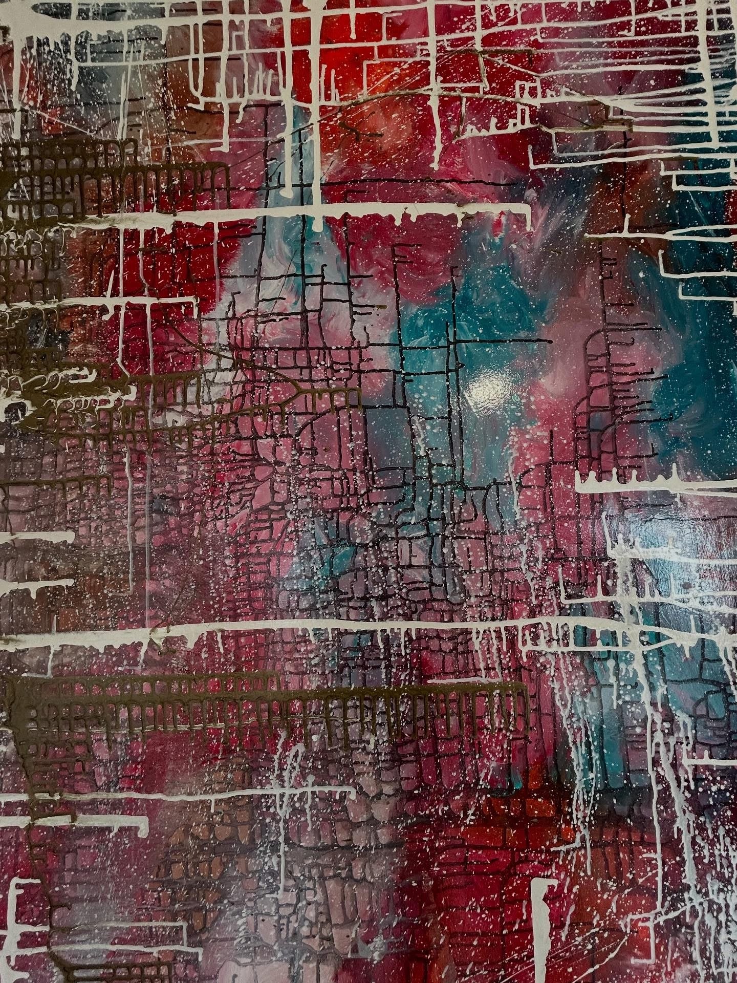 Abstract painting with a cityscape of brick buildings and roads in red, pink, blue, white, and black colors, created with layered spray paint and drip effects.