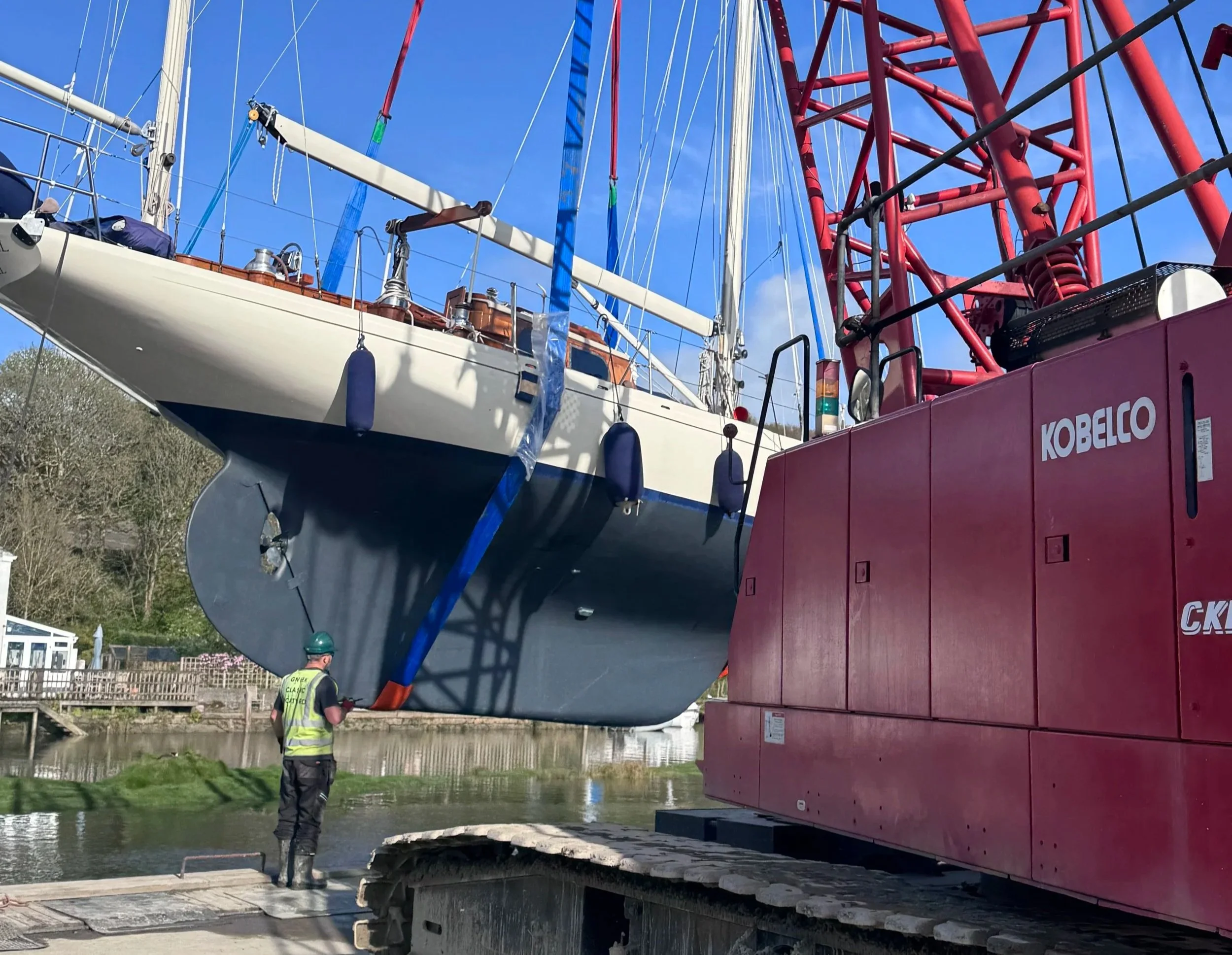 A boat being craned into the water at Gweek Classic Boatyard in Cornwall