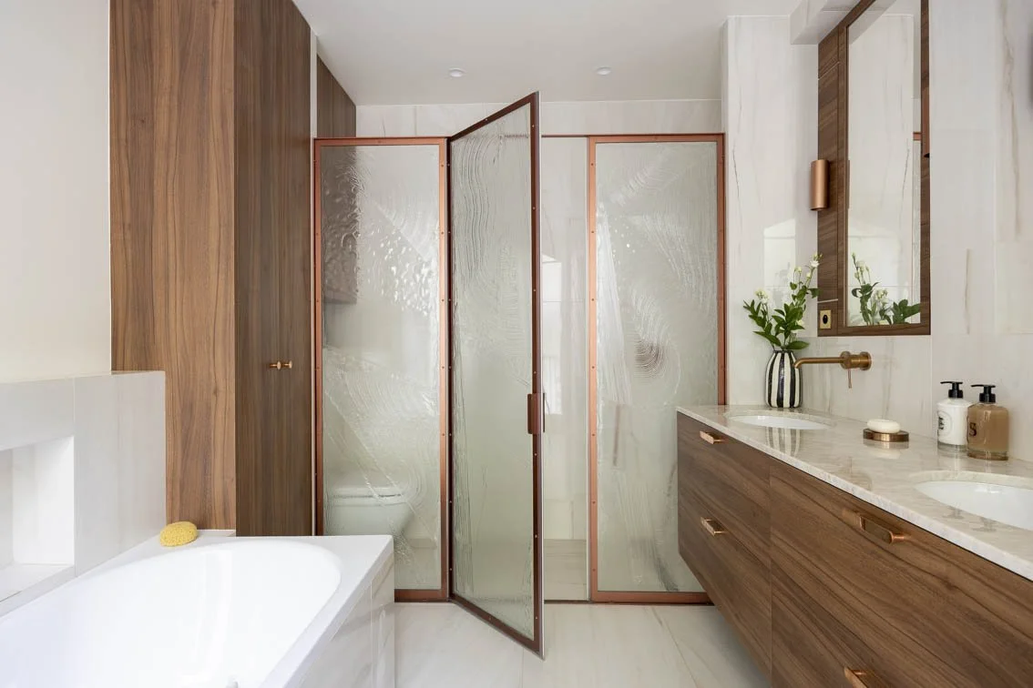 SALLE DE BAIN DE CARACTERE Une salle de bain comme une ode aux beaux matériaux: marbre, onyx, noyer, verre sculpté et laiton. Un bel espace avec une ambiance entre raffinement et caractère, où chaque détail raconte une histoire. 