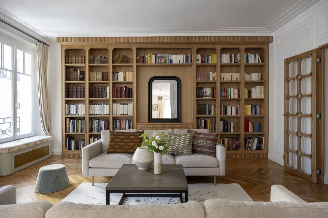 LE SALON Avec cette incroyable bibliothèque sur mesure en massif chêne, le salon a pris une nouvelle dimension. D’inspiration Art Déco, cet ouvrage réalisé par nos menuisiers permet de ranger de nombreux livres et aussi de cacher un écran et u