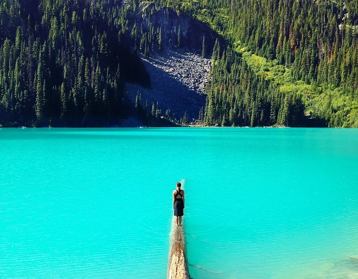 Woman+standing+on+log+in+water.jpg