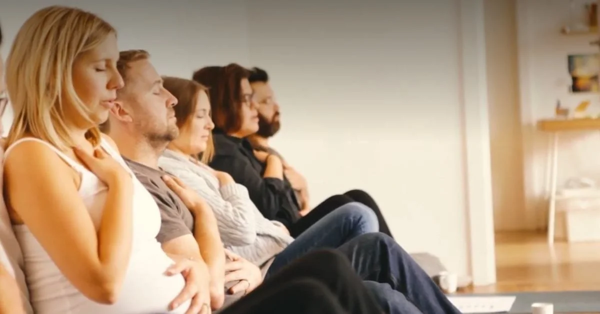 five seated adults with eyes closed hands on chest and tummy practice self hypnosis