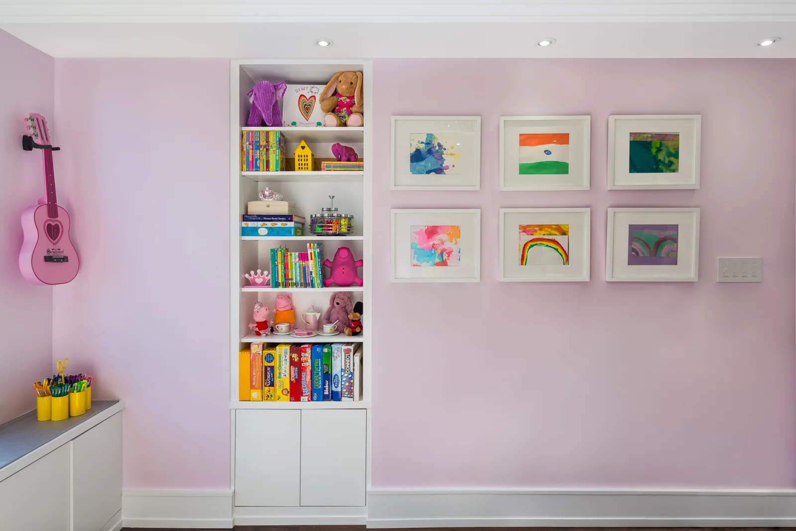 Facing the bed is the gallery wall showing artwork made by the budding artist. This of course is a rotating gallery space which can be easily updated. We designed a built in a bookcase with both open and closed storage for books, games and clutter. 