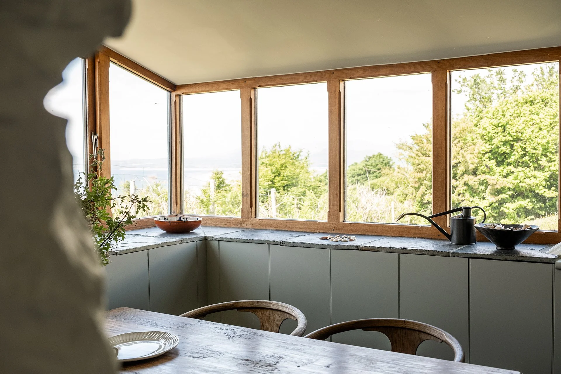 kitchen interior designer near me featuring modern kitchen storage, custom kitchen worktops, bespoke wooden table, modern kitchen chairs and ceramic plates