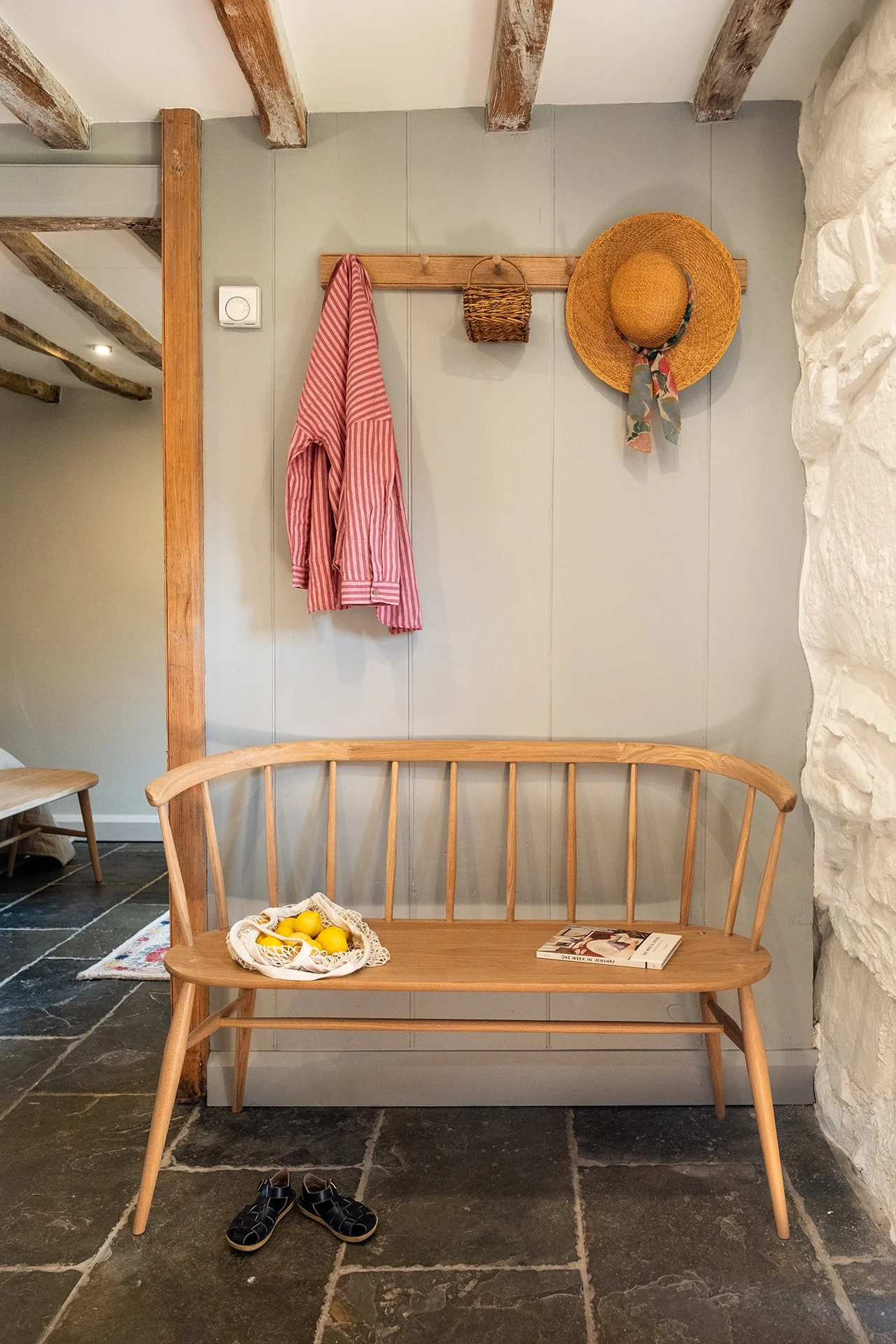 megan griffin luxury interior design studios near me featuring bespoke wood bench, coat hook, plastered exposed stone wall, slate floor tiles and wooden beams