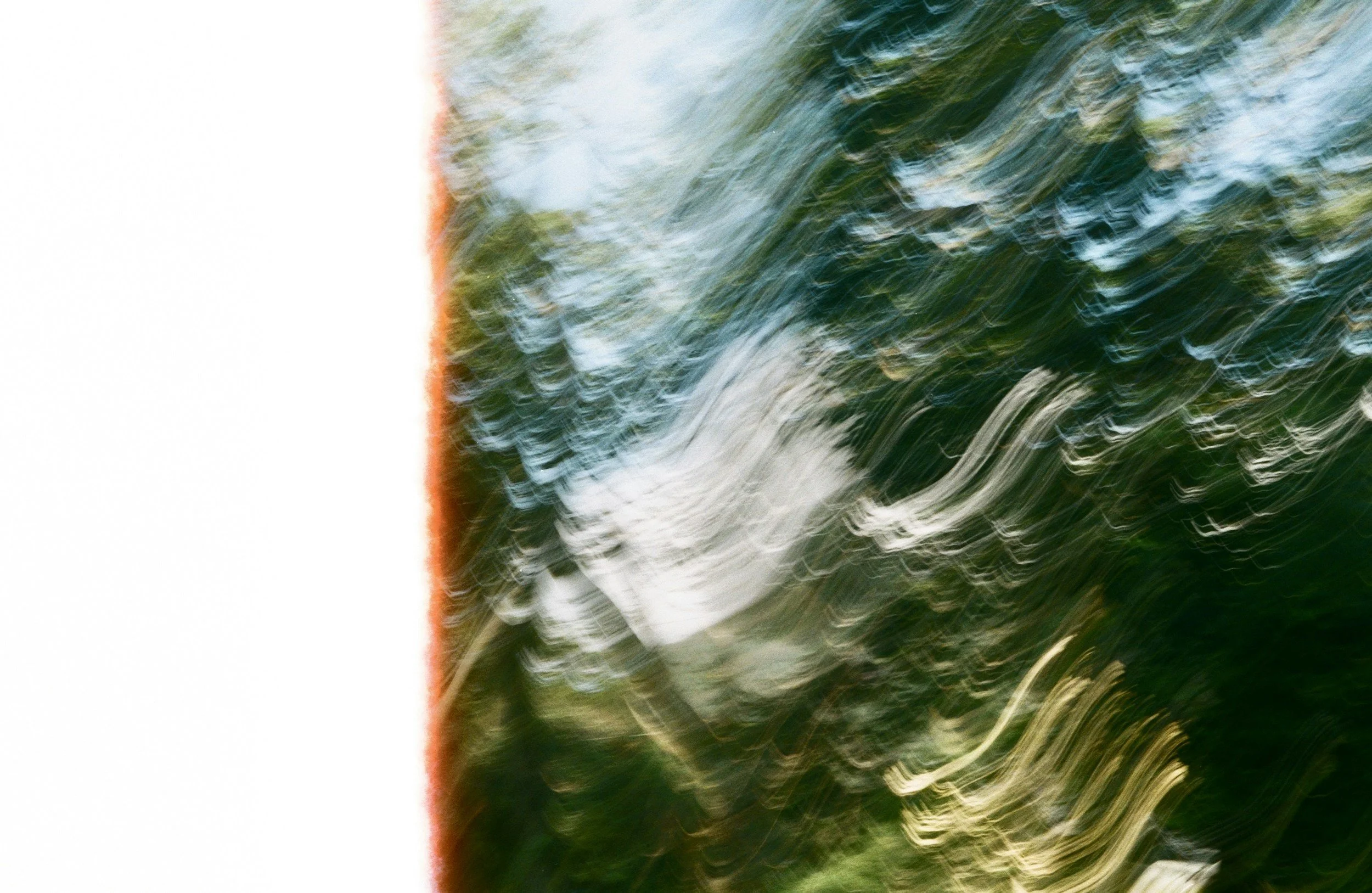 Abstract image with green, yellow, and white swirling patterns and a red-orange line on the left side.