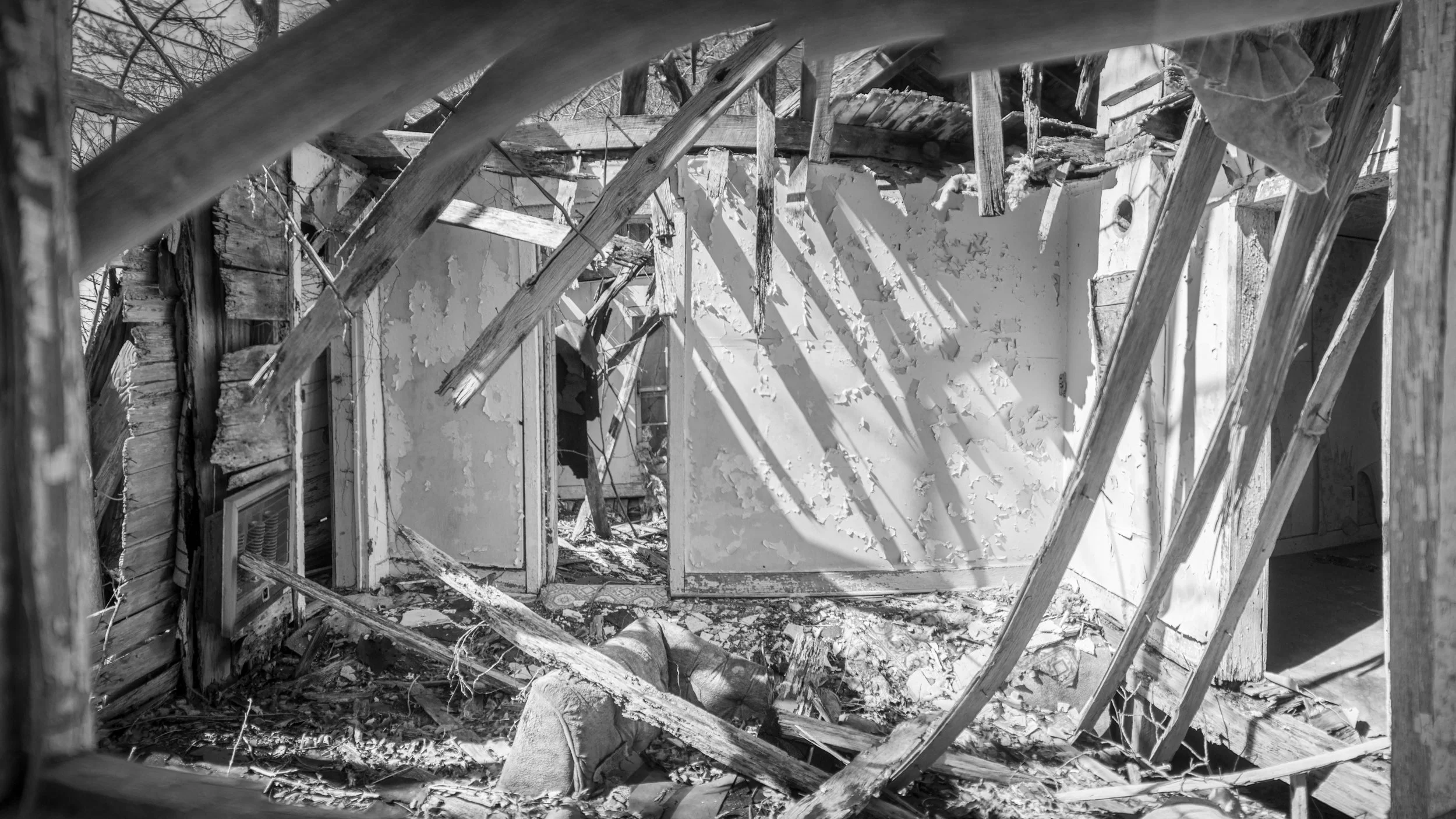 Collapsed interior of an abandoned house with light through the slats near Bowker Road, Tennessee, black and white photograph from My Tennessee by Adam CK Vollick