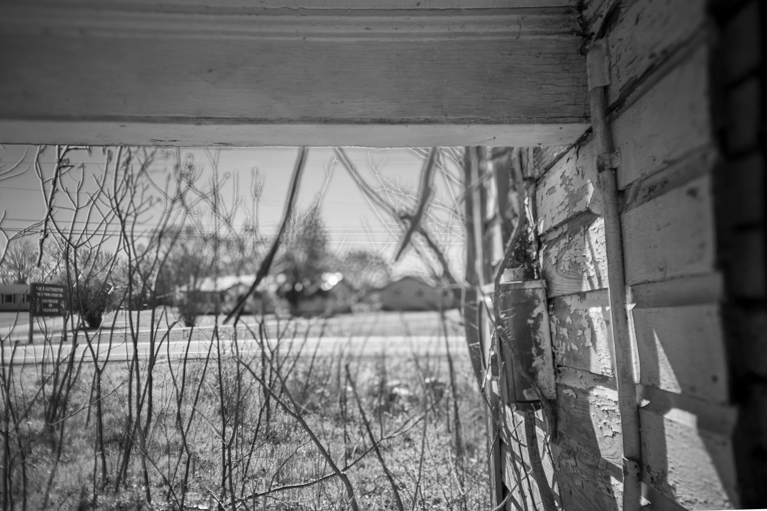 View from an abandoned doorway out to the fields near Bowker Road, Tennessee, black and white photograph from My Tennessee by Adam CK Vollick
