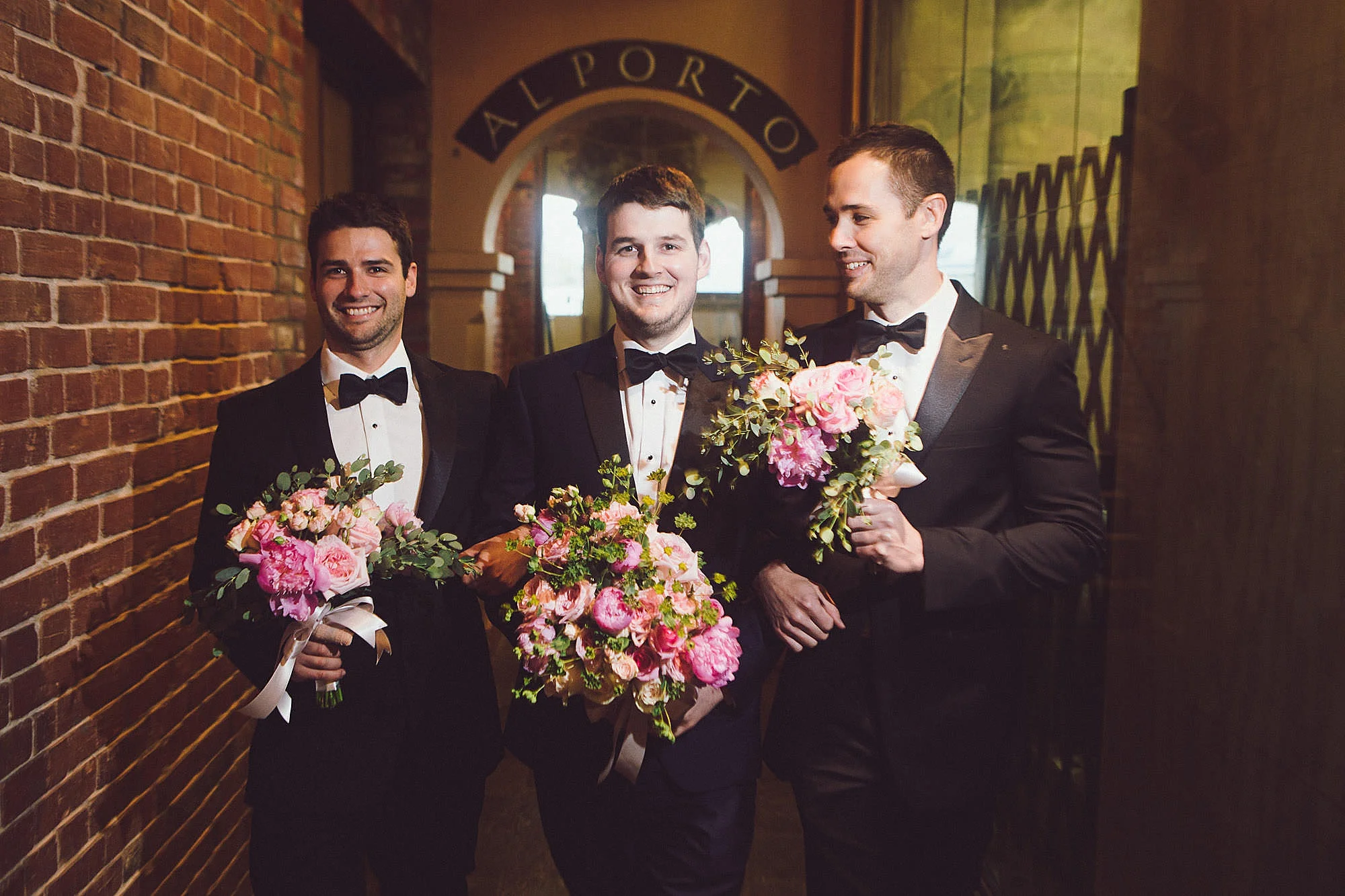 Groom and groomsmen holding flowers