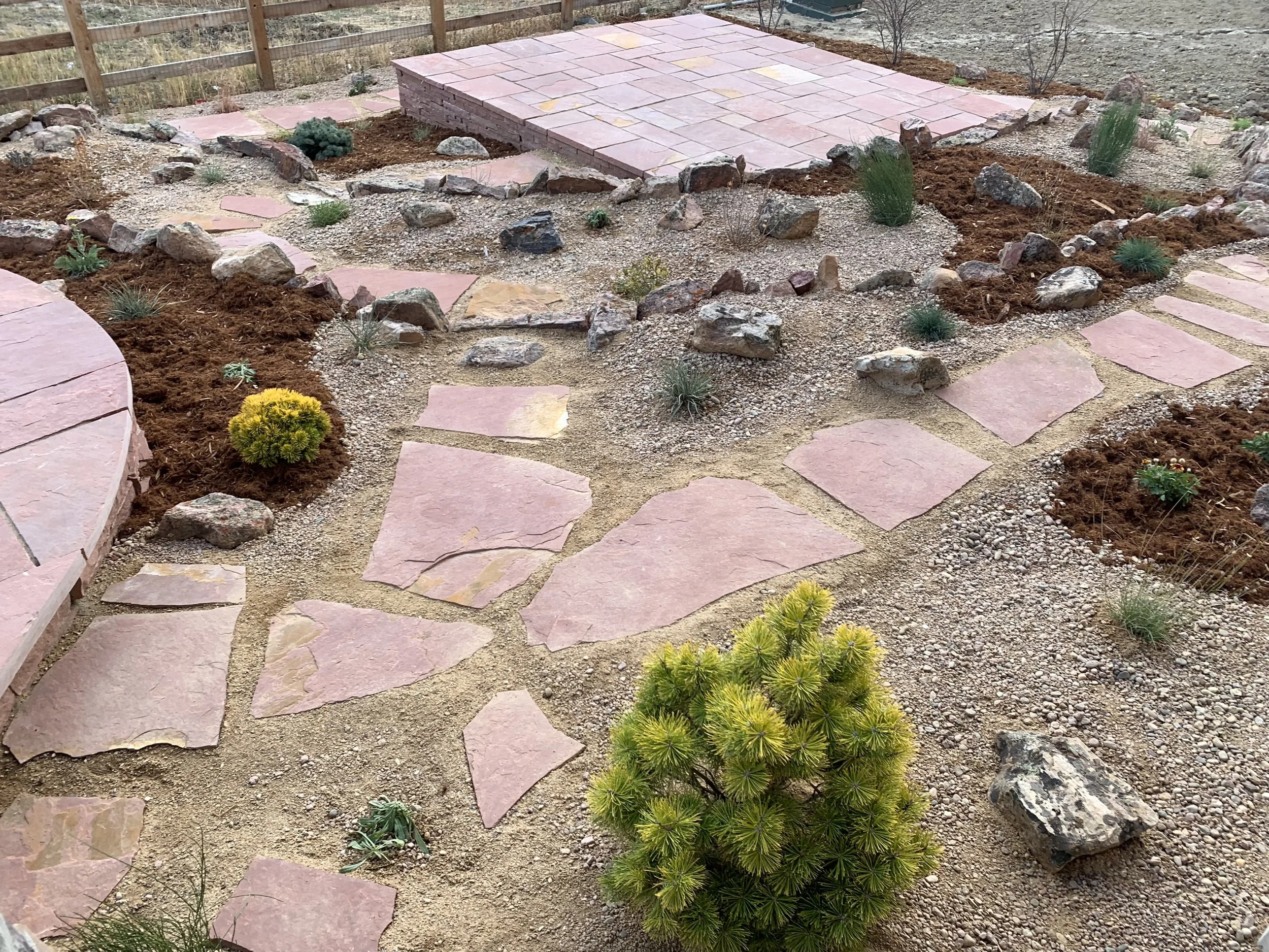 Red flagstone pathways with low water plants in Colorado