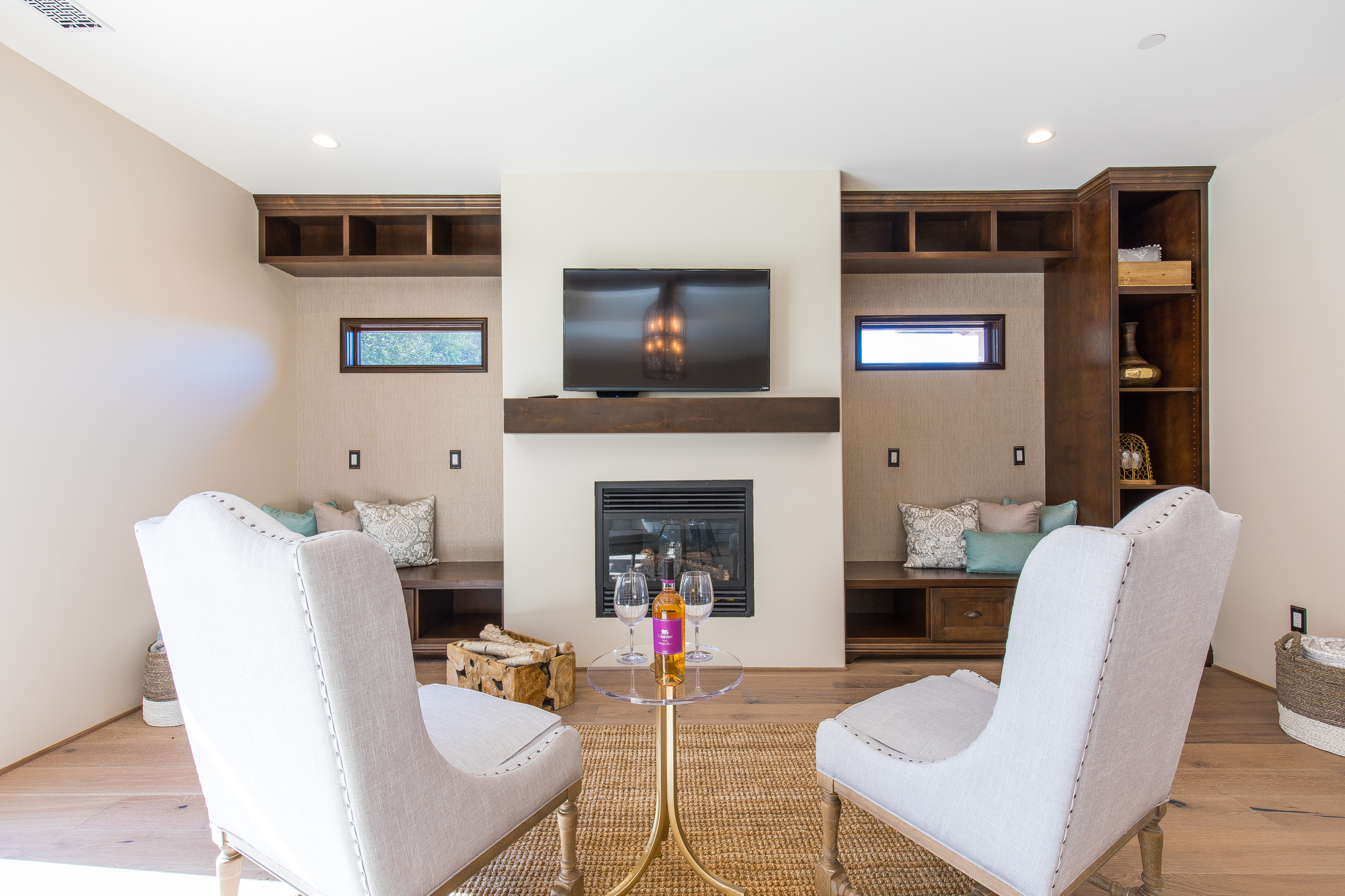  Custom made bench seating and open bookcase cabinetry flank the gas fireplace which sits below a hand-distressed and hand-stained wood mantle 