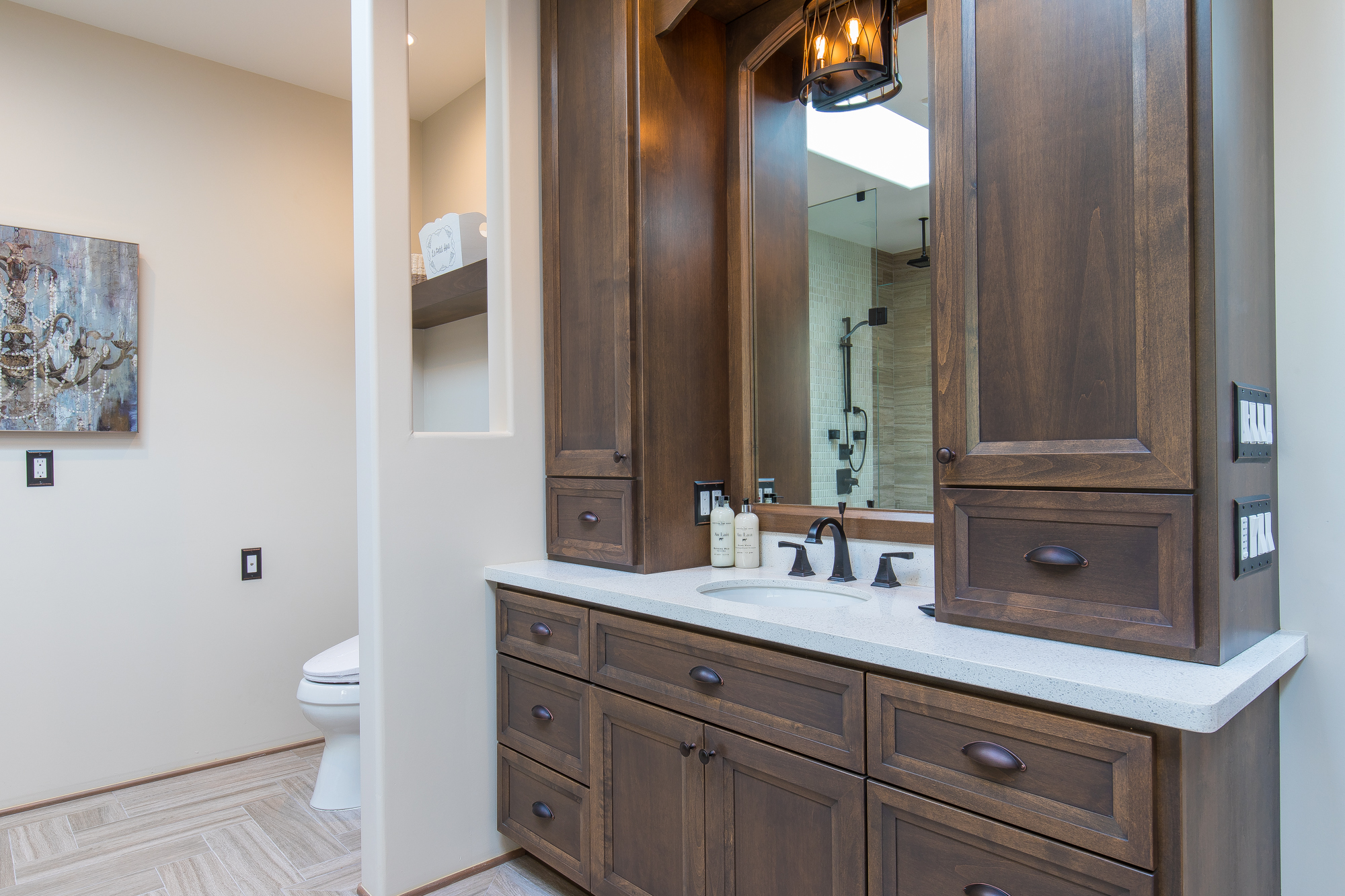  Two separate custom made vanities with countertop cabinet towers and pull out hampers provide ample storage for toiletries 