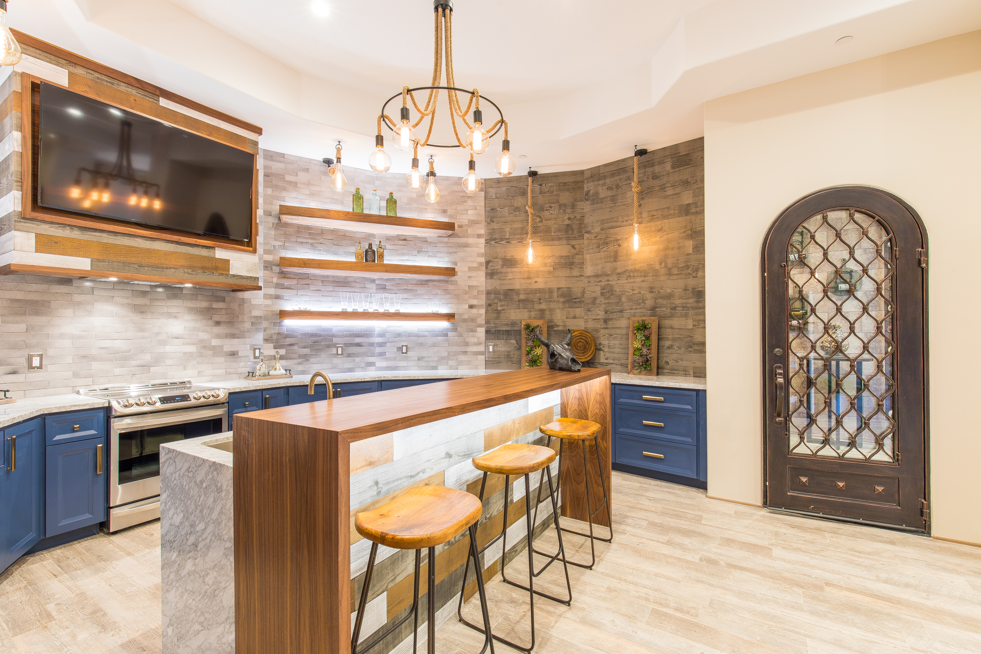  The lower level kitchen and bar consists of custom made painted cabinetry comprised of all American plywood and hardwood with top of the line soft close Blum hardware, stainless steel appliances, and appliance lift and floating shelves made of walnu