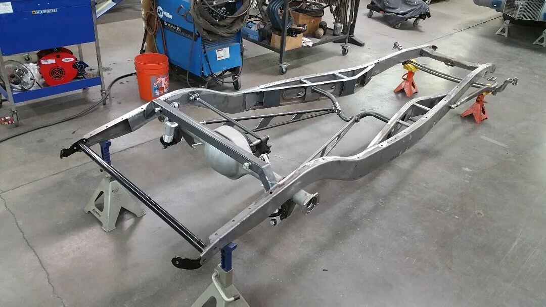 We built the chassis for Coby's coupe in house, starting with a pair of repop outer frame rails and Chassis Engineering X member rails.  I pitched the idea of using '46-'48 front wishbone arms flipped upside down to tuck the headers up, and I drew th