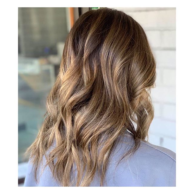 Beautiful bronde curls shimmering in the light, brought to life with highlights.