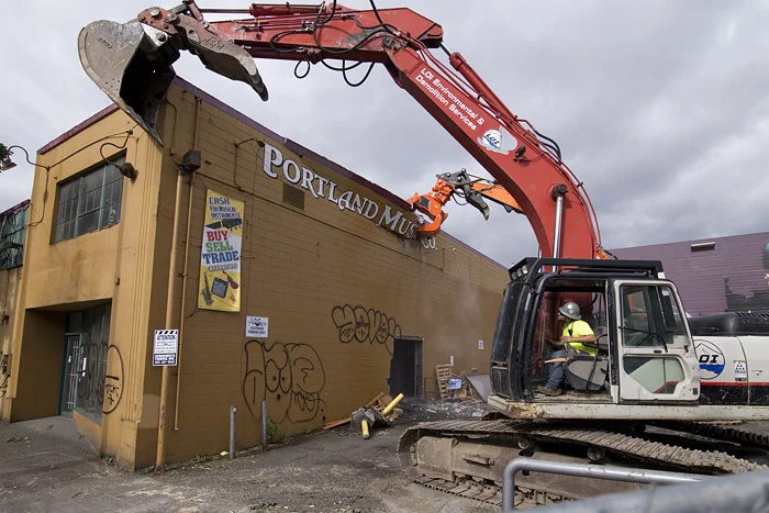  Kyle Berens uses an excavator to support the building as the demolition of the structure begins. 
