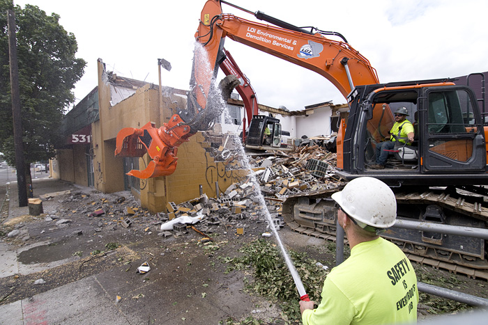  Jake Wagner, bottom right, of LOI Environmental &amp; Demolition Services, sprays to contain dust Tuesday morning during the demolition of the former Portland Music Co. building on Southeast Martin Luther King, Jr. Boulevard. 