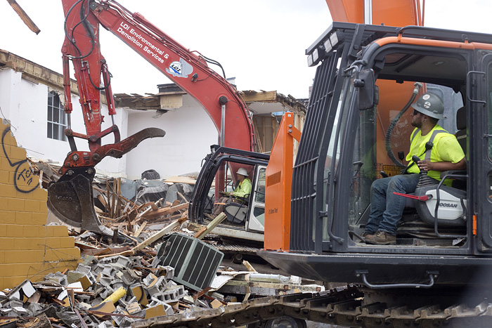  LOI employees Kyle Berens, foreground, and Jeff Wagner demolish the structure. 