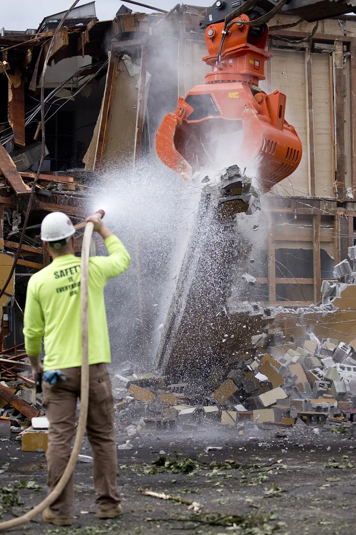  Jake Wagner sprays to contain dust as the structure is brought down. 
