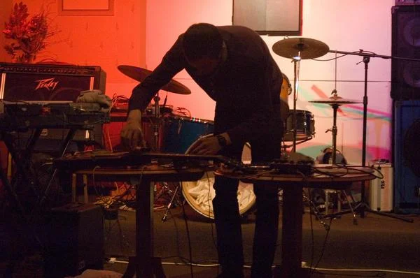 Performing with electric guitar, contact mics, tape recorder and objects.