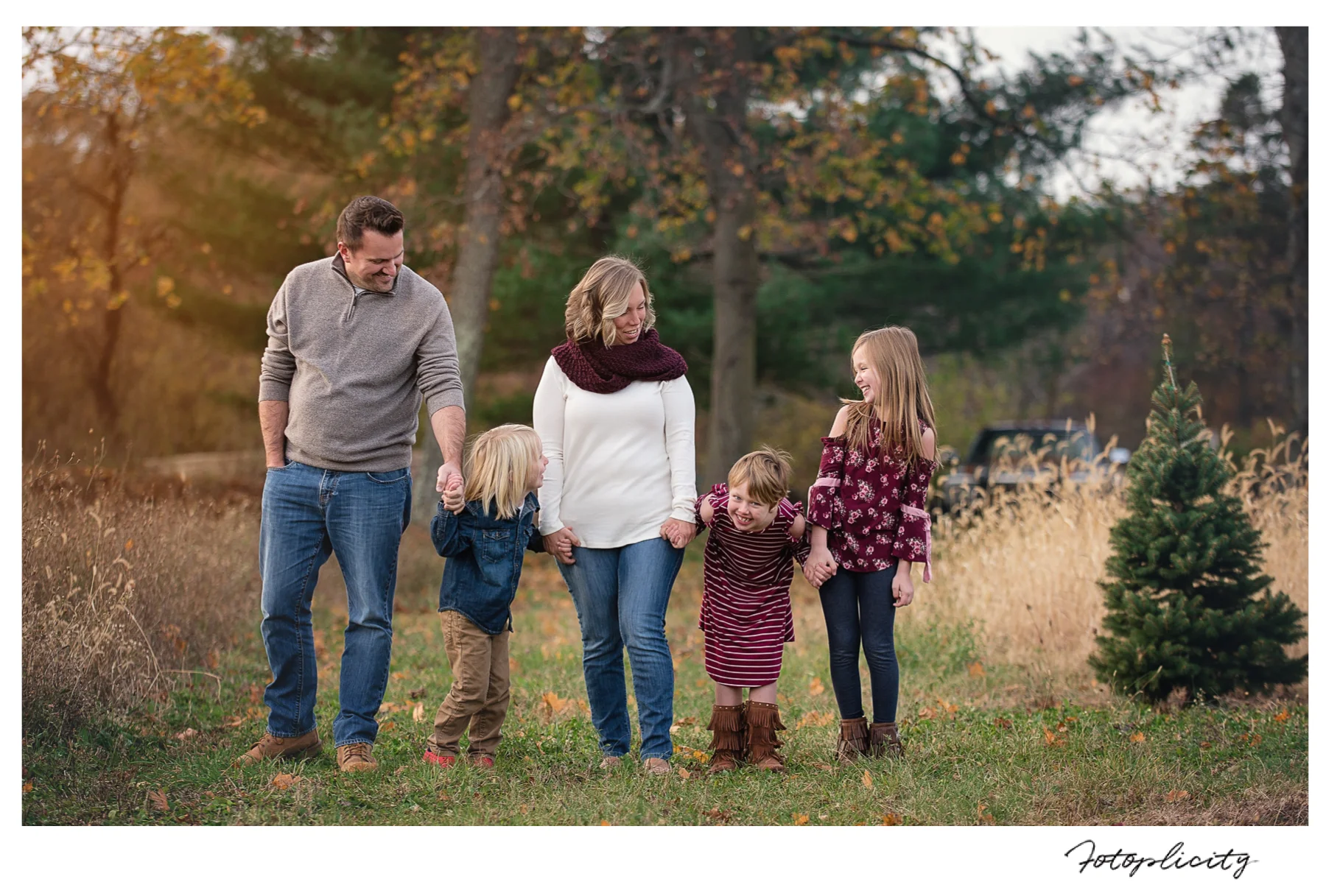 Family walking in field by Fotoplicity