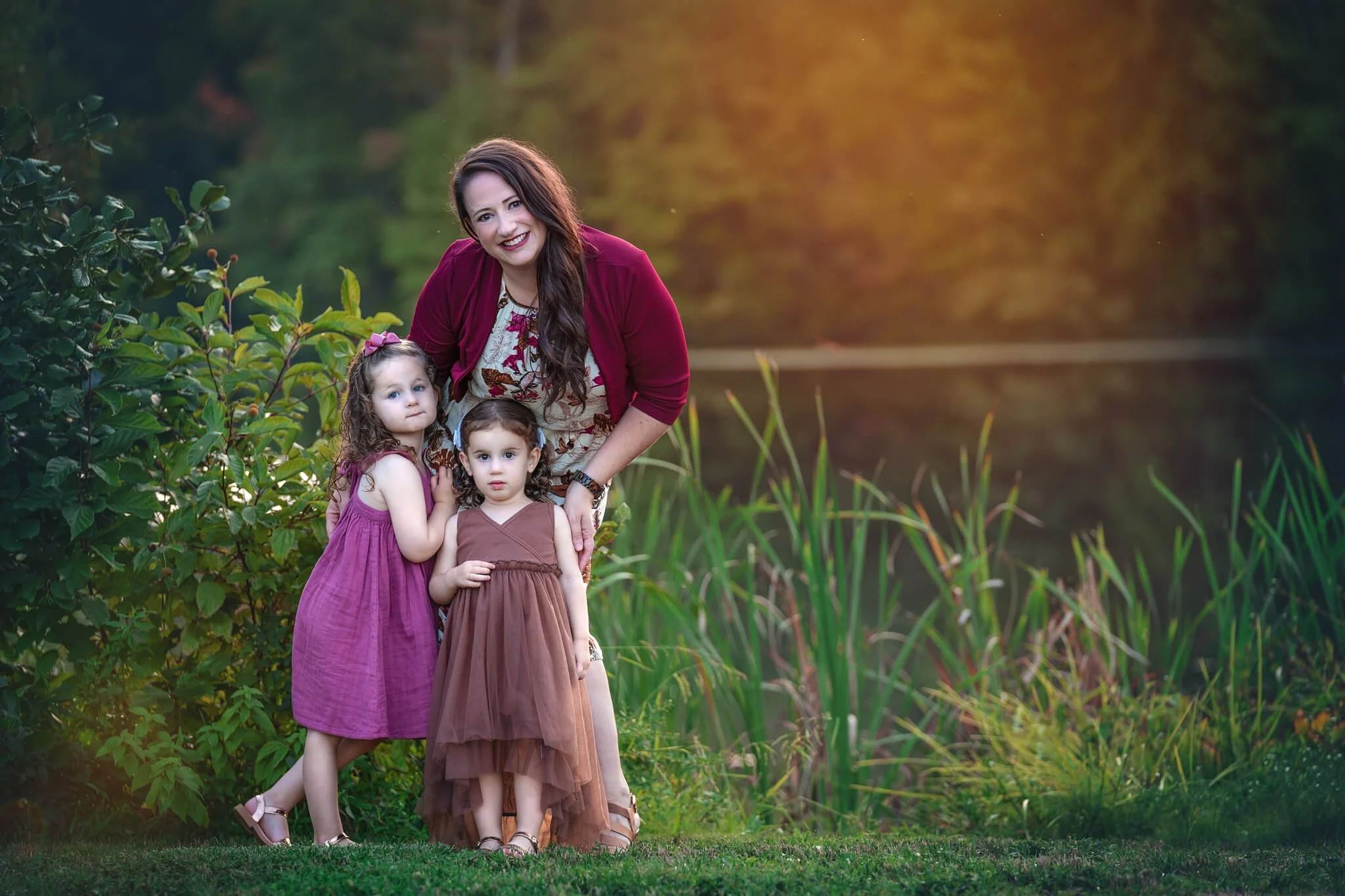 Mother standing with her two young daughters during a golden hour outdoor family photography session in North Brunswick, New Jersey.