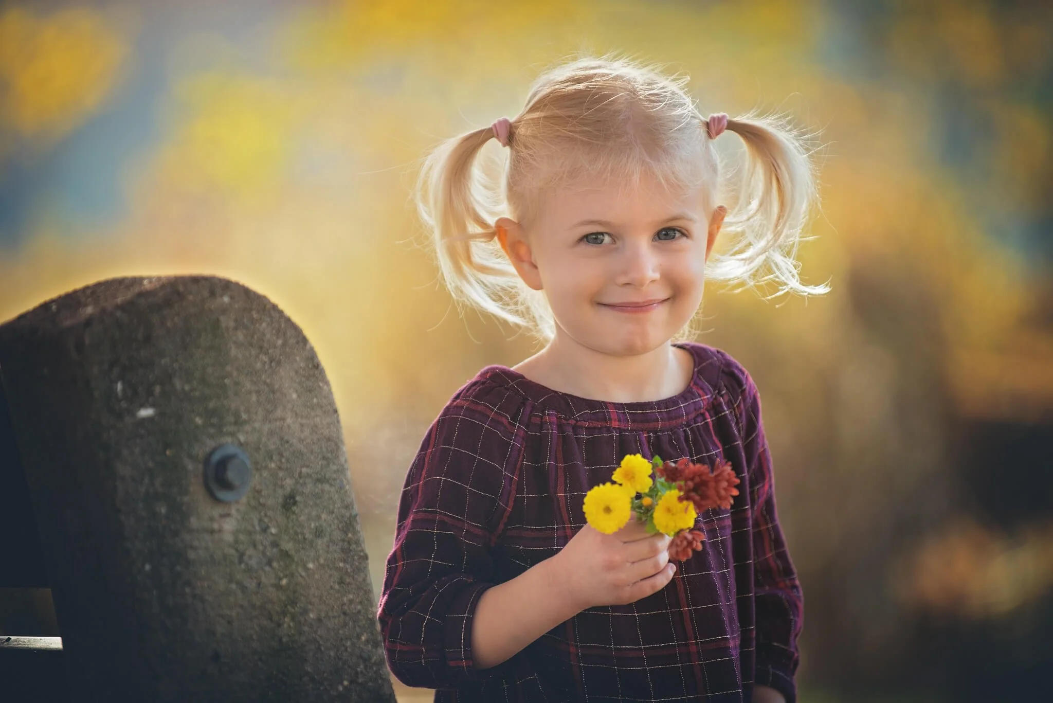 Child holding small flowers during a golden hour outdoor birthday milestone portrait session at Donaldson Park in Highland Park, New Jersey.