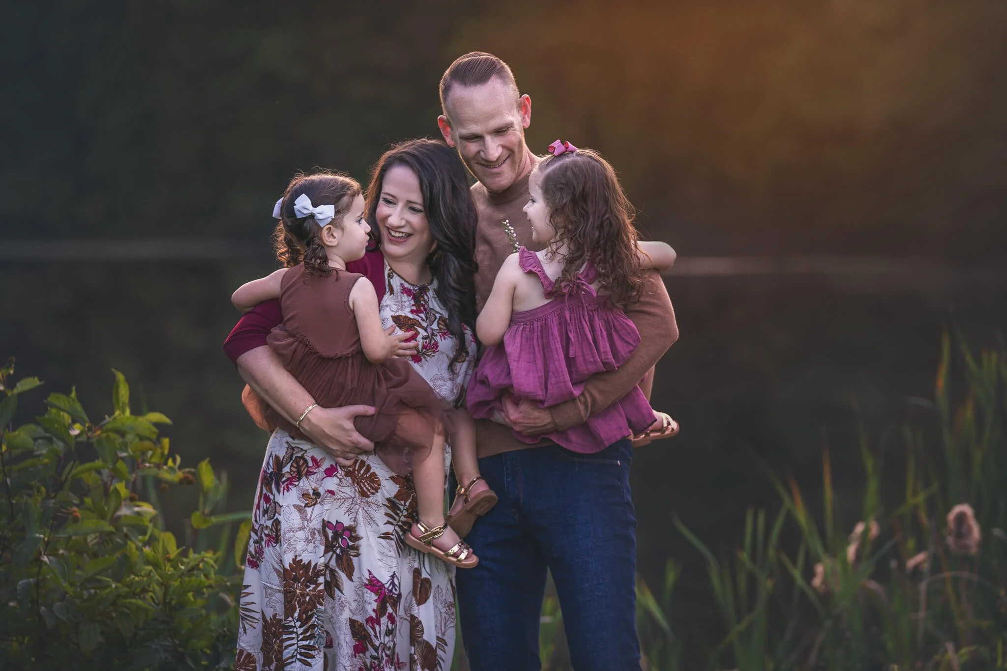 Family of four during a golden hour outdoor family session at a park in East Brunswick, New Jersey, photographed by Fotoplicity.