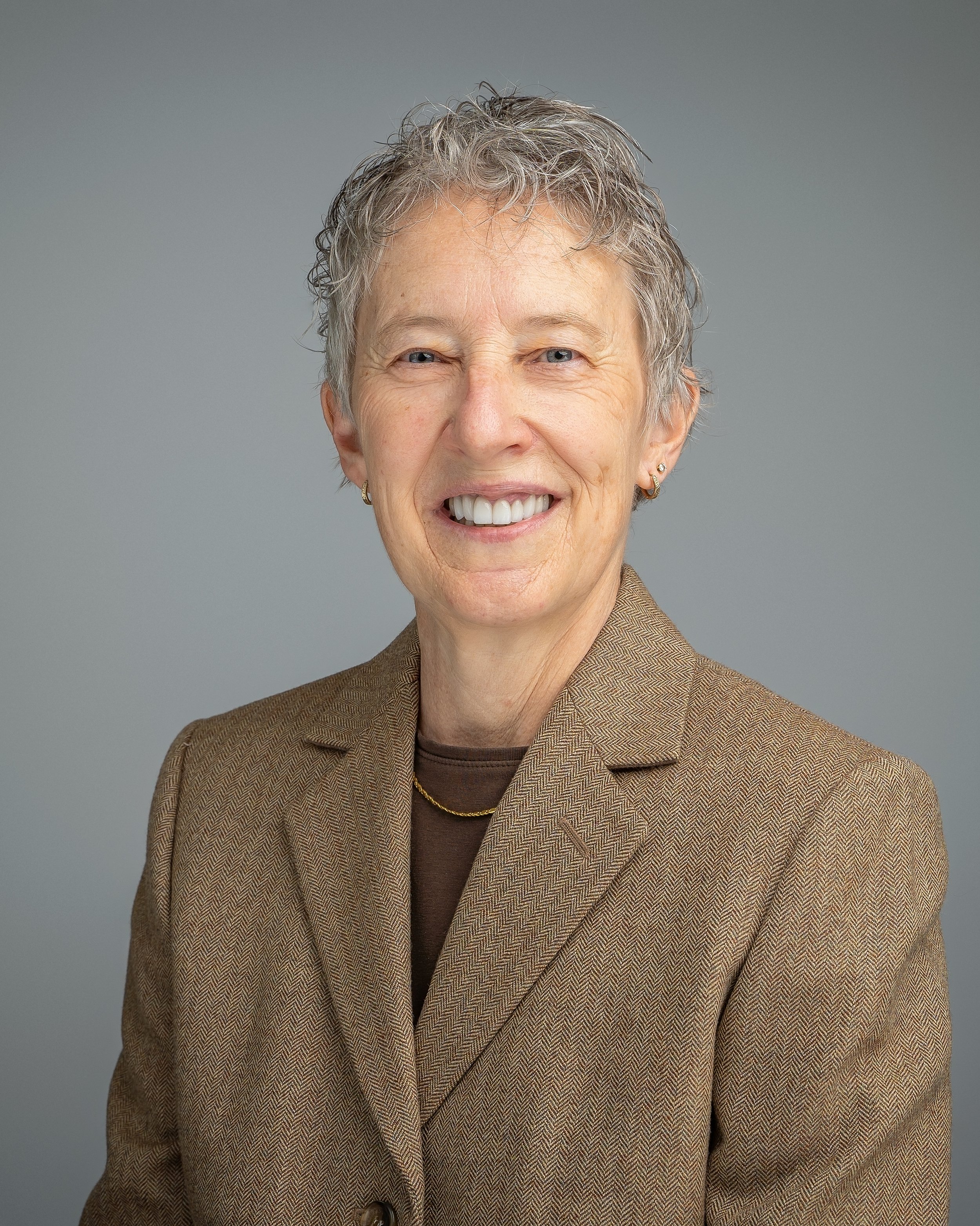 Professional headshot of a woman on a gray background, photographed at Fotoplicity studio in East Brunswick NJ