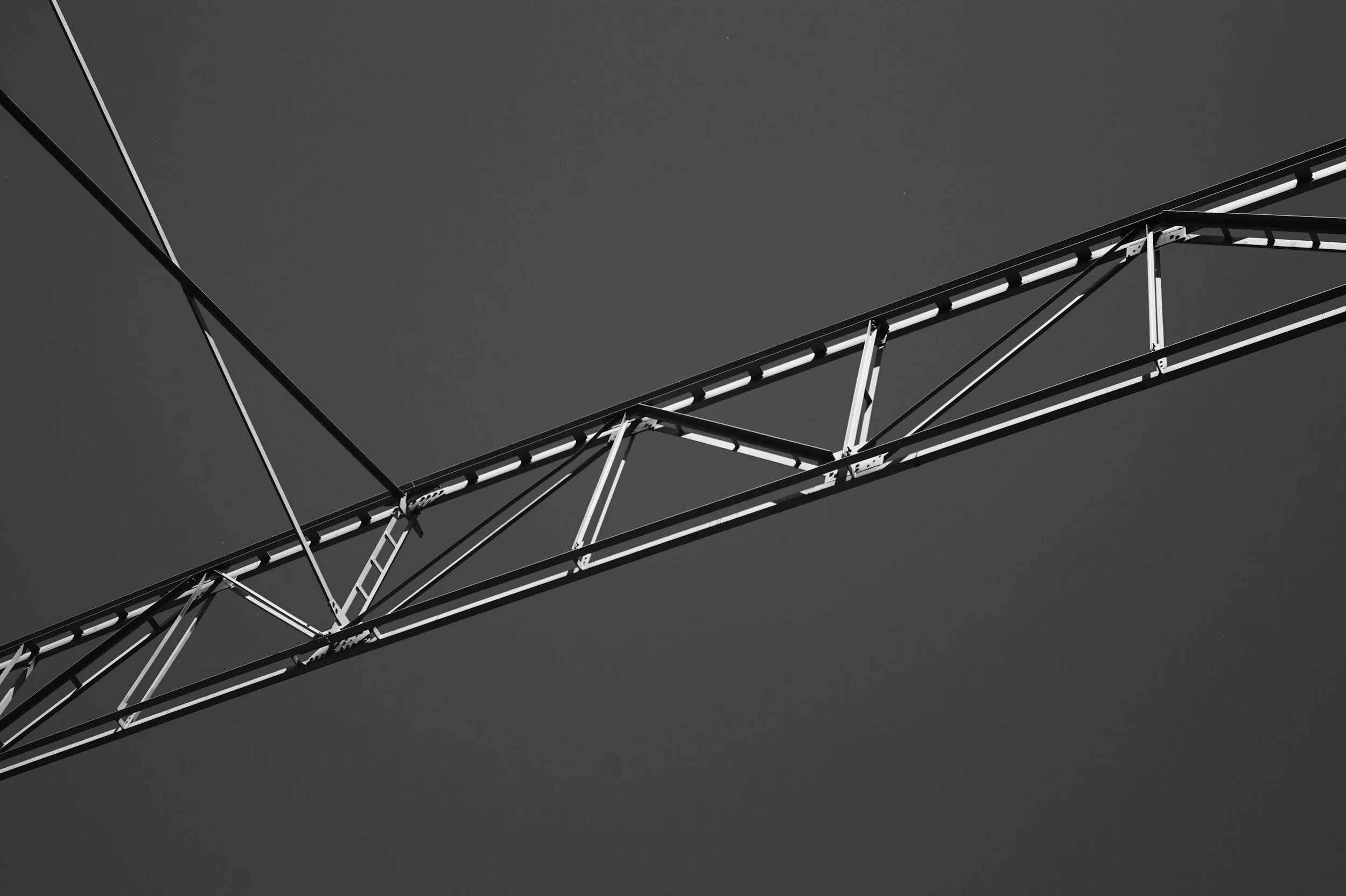 Close-up view of a metal roller coaster track against a clear sky.