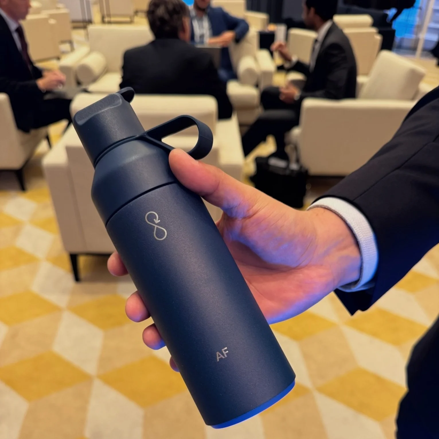 Guest holding a personalised water bottle during the ICG event