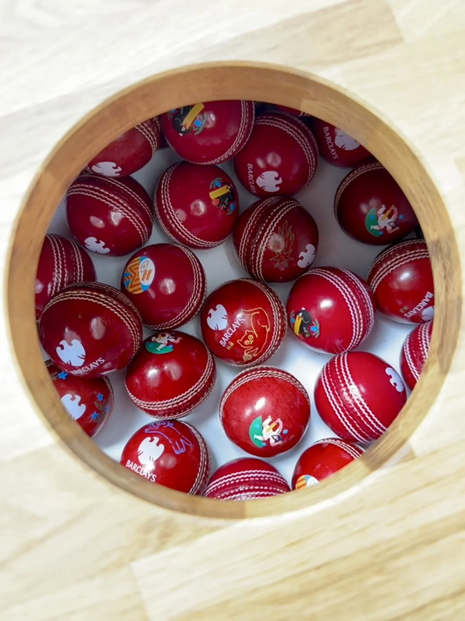 Collection of red cricket balls featuring custom printed designs