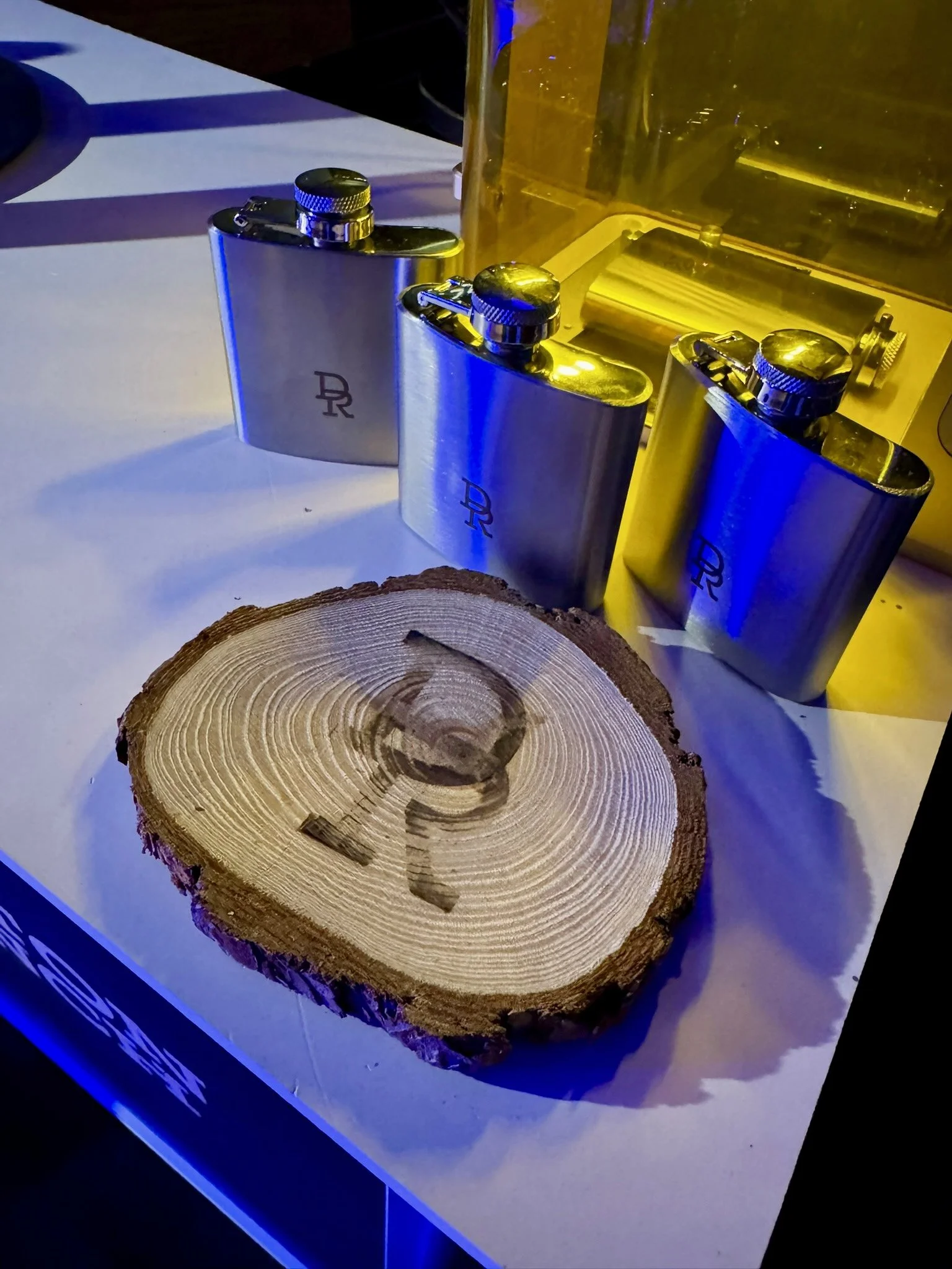 Close-up of a hip flask being laser engraved at the event